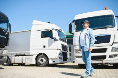 Üst düzey yakışıklı kamyonetinin önünde poz.