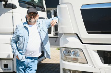 Kamyonun önünde yürüyen kıdemli bir adam..