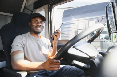 Şoför, modern kamyonun taksisinde telsiz kullanıyor.