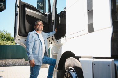 Üst düzey yakışıklı kamyonetinin önünde poz.