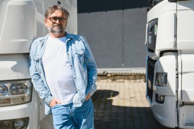 Kamyonetinin önünde duran kendinden emin mutlu erkek sürücü..