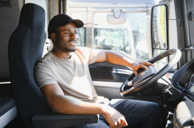 Profesyonel Afro-Amerikan kamyon şoförü günlük giysiler içinde kamyon şoförü uzun bir ulaşım yoluna gidiyor..