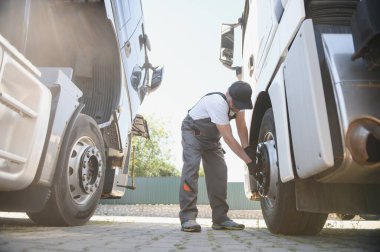 Caucasian Professional Truck Mechanic Rebuilding Heavy Duty Truck Diesel Engine. Automotive Industry Theme.