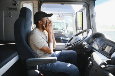 Çalışmaktan yoruldum. Kulübede oturuyor. Genç Afro-Amerikan kamyon şoförü gündüz vakti aracıyla geliyor..