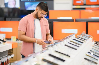 Elektronik mağazasından yeni cep telefonu alan yakışıklı delikanlıyı yakından çek..