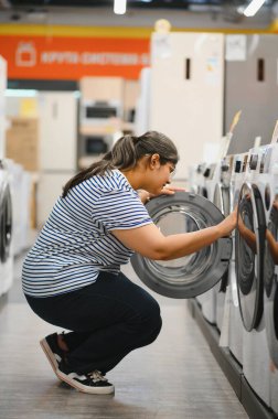 Hintli kadın bir ev aletleri dükkanından buzdolabı seçiyor..