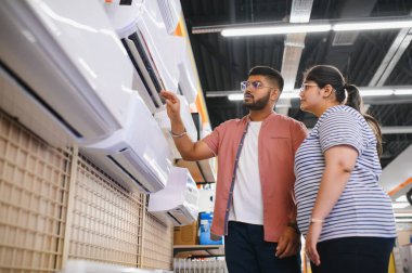 Güzel bir çift bir elektronik mağazasından klima seçiyor..