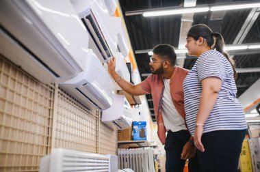 Güzel bir çift bir elektronik mağazasından klima seçiyor..