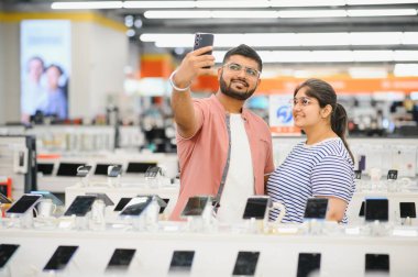 Yeni bir dijital cihaz alıyorum. Mutlu çift mağazadan akıllı telefon alıyor..