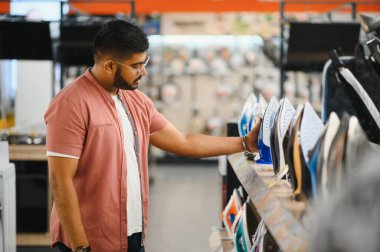 Depoda elektrikli demir seçen bir adam