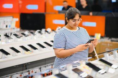 Teknoloji mağazasında telefonu seçen kadın..