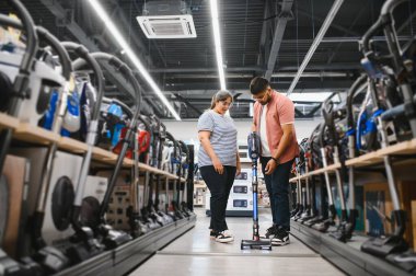 Genç, güzel Hintli çift teknoloji mağazasından yeni elektrikli süpürge alıyor..