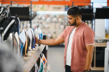 Depoda elektrikli demir seçen bir adam