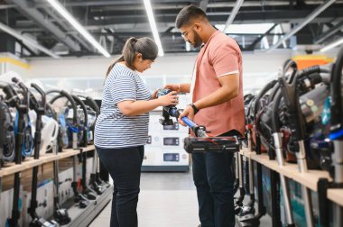 Genç, güzel Hintli çift teknoloji mağazasından yeni elektrikli süpürge alıyor..