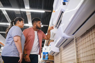 Güzel bir çift bir elektronik mağazasından klima seçiyor..