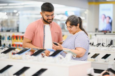 Hintli çift mağazada yeni akıllı telefon arıyor..