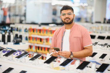 Cep telefonu dükkanındaki Hintli müşteri yeni akıllı telefonunu seçiyor..