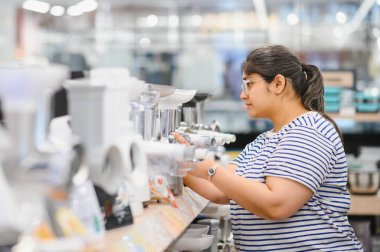 genç kadın ev aletleri alışveriş merkezi süpermarkette mutfak karıştırıcı blender seçimi.