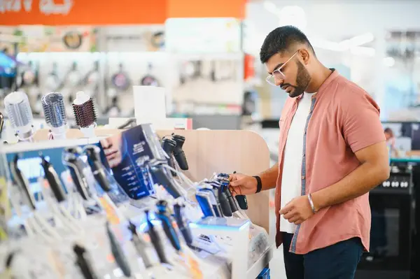 stock image Man choosing trimmer at electric store