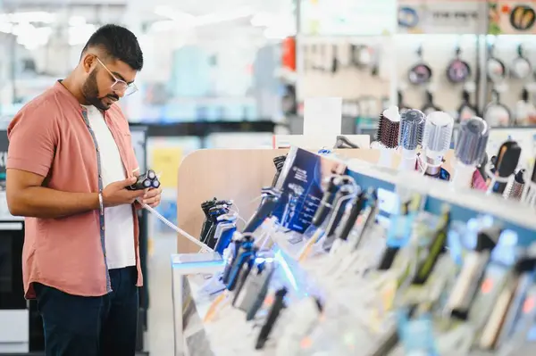 stock image Man choosing trimmer at electric store