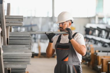 Fabrikada güvenlik önlüğü giyen mutlu Hintli erkek mühendis..