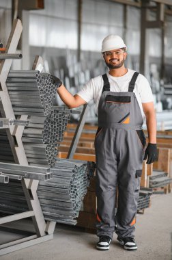 Portrait Indian male staff worker engineer supervisor in safety suit work in factory warehouse.