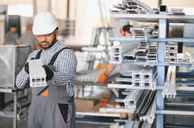 Portrait Indian male staff worker engineer supervisor in safety suit work in factory warehouse.