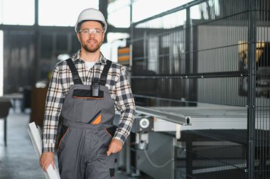 Fabrika işçisi. Miğferli adam PVC ile çalışıyor..