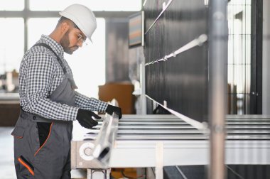 Makine operatörü. Fabrikada sanayi işçisi. Beyaz şapkalı genç teknisyen..