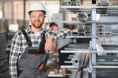 Fabrika işçisi. Miğferli adam PVC ile çalışıyor..
