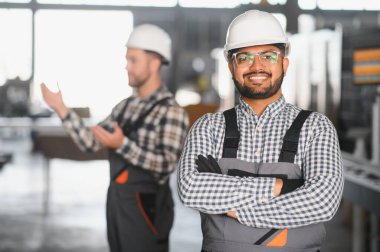 Metal-plastik pencere ve kapı üretimi için bir fabrikada iki işçi..