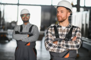 İki erkek uluslararası işçi alüminyum PVC pencere ve kapı üretimi için bir makinede birlikte çalışıyorlar..