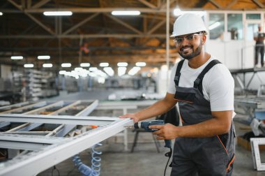 Makine operatörü. Fabrikada sanayi işçisi. Beyaz şapkalı genç teknisyen..