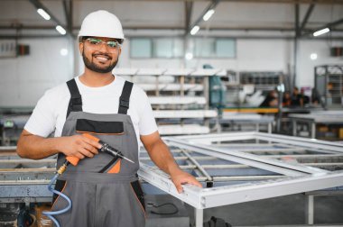 Fabrikada güvenlik önlüğü giyen mutlu Hintli erkek mühendis..