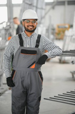 Makine operatörü. Fabrikada sanayi işçisi. Beyaz şapkalı genç teknisyen..