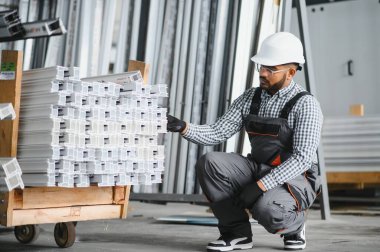 Portrait Indian male staff worker engineer supervisor in safety suit work in factory warehouse.