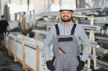 Fabrikada güvenlik önlüğü giyen mutlu Hintli erkek mühendis..