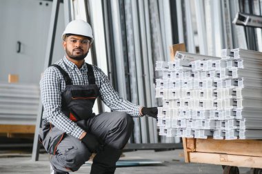 Portrait Indian male staff worker engineer supervisor in safety suit work in factory warehouse.