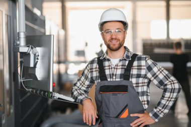 Fabrika erkek sakallı işçi bir CNC değirmen makinesini kopyalama alanı ile programlıyor..