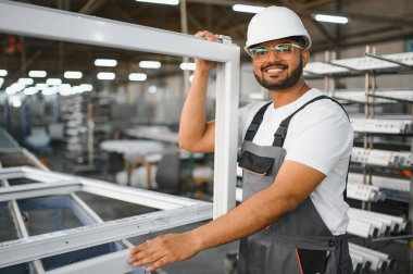 Makine operatörü. Fabrikada sanayi işçisi. Beyaz şapkalı genç teknisyen..