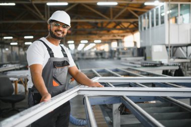 Makine operatörü. Fabrikada sanayi işçisi. Beyaz şapkalı genç teknisyen..