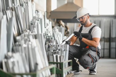 Modern fabrikada şapka takan neşeli genç işçilerin portresi..