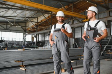 Metal işleme, metal borular ve profil üretimi. Fabrikada iki uluslararası işçi.