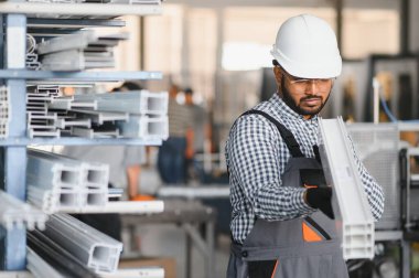 Modern fabrikada şapka takan neşeli genç işçilerin portresi..