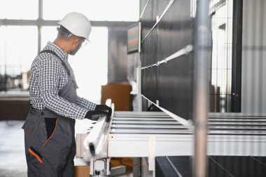 Pencere ve kapılar için çerçeve yapan PVC işçisi veya operatörü.