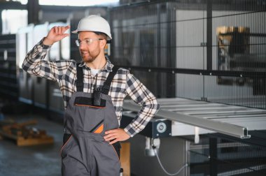 Fabrika işçisi. Miğferli adam PVC ile çalışıyor..