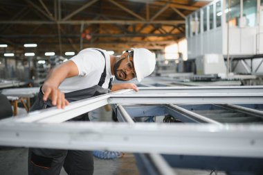 Pencere ve kapılar için çerçeve yapan PVC işçisi veya operatörü.