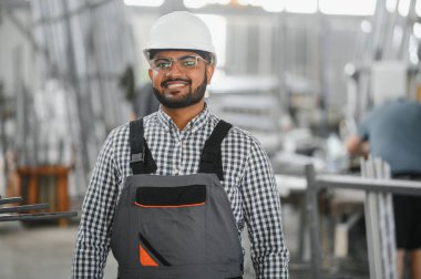 Makine operatörü. Fabrikada sanayi işçisi. Beyaz şapkalı genç teknisyen..