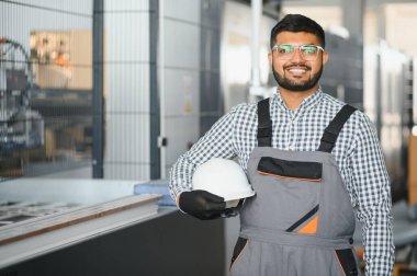 Fabrikada güvenlik önlüğü giyen mutlu Hintli erkek mühendis..