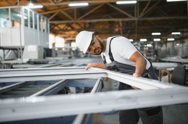 Portrait Indian male staff worker engineer supervisor in safety suit work in factory warehouse.